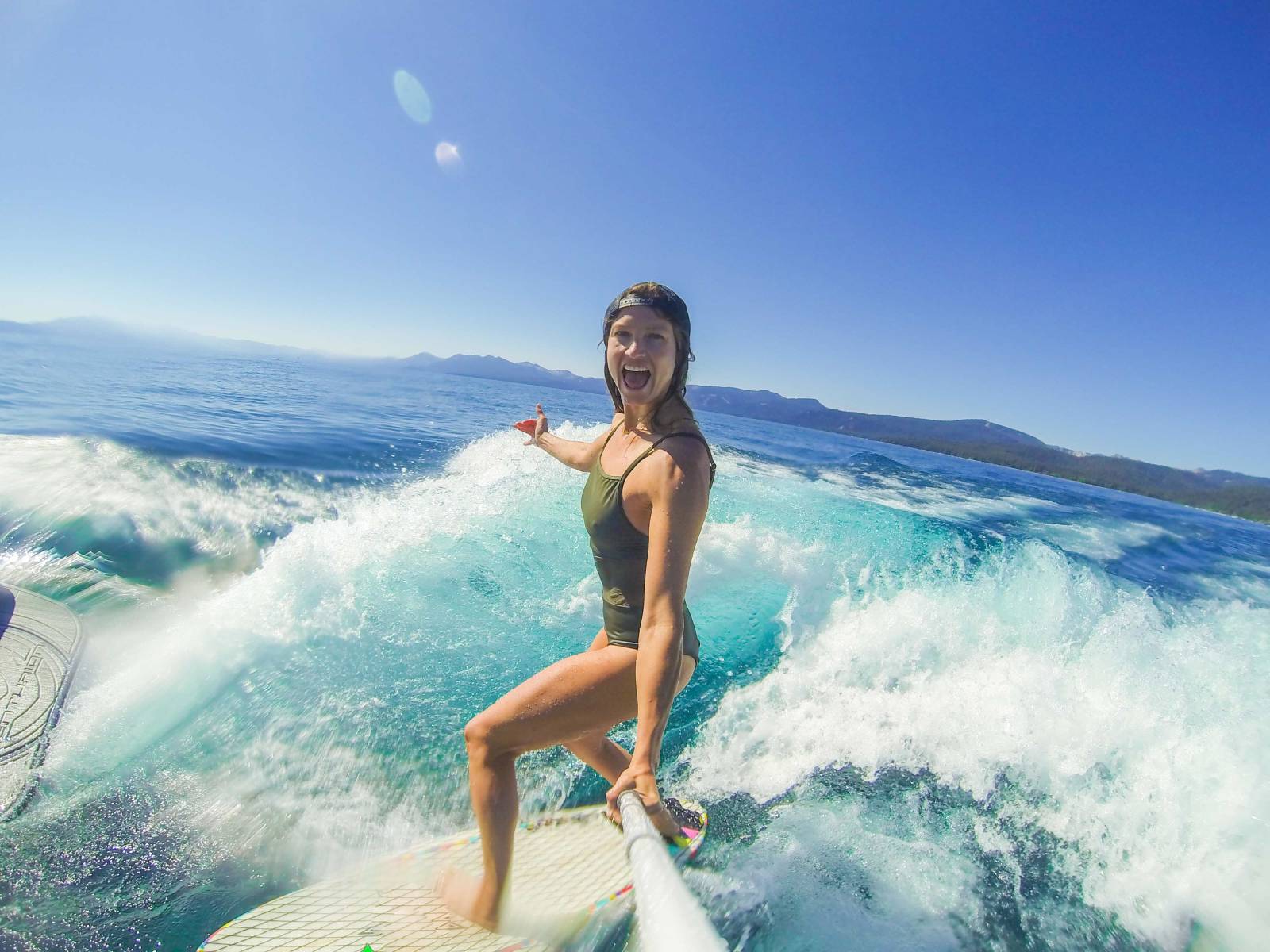Julia Mancuso surfing with a selfie stick on Tavarua Island